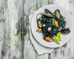 Mediterranean pasta. Spaghetti with cuttlefish ink and clams. photo