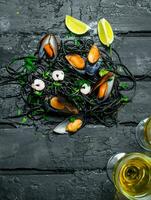 Mediterranean food. Spaghetti with cuttlefish ink, clams and white wine. photo