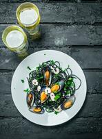 Mediterranean food. Spaghetti with cuttlefish ink, clams and white wine. photo