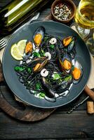 Mediterranean food. Spaghetti with cuttlefish ink, clams and white wine. photo