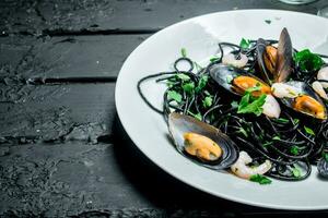 Mediterranean food. Spaghetti with cuttlefish ink and clams. photo