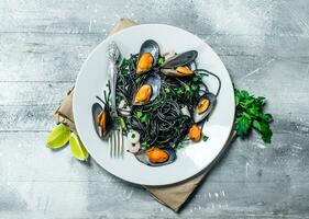 Mediterranean pasta. Spaghetti with cuttlefish ink and clams. photo