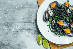Mediterranean pasta. Spaghetti with cuttlefish ink and clams. photo