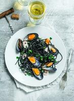 Mediterranean pasta. Spaghetti with cuttlefish ink, clams and white wine. photo