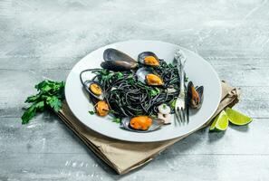 Mediterranean pasta. Spaghetti with cuttlefish ink and clams. photo