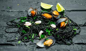 Mediterranean food. Spaghetti with cuttlefish ink and clams. photo