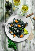 Mediterranean pasta. Spaghetti with cuttlefish ink, clams and white wine. photo