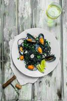 Mediterranean pasta. Spaghetti with cuttlefish ink, clams and white wine. photo