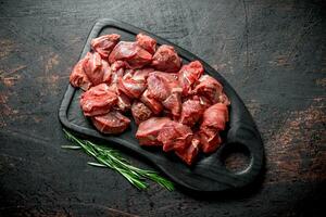 Cut raw beef on a cutting Board with rosemary. photo