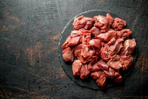 Sliced raw beef on a black stone Board. photo