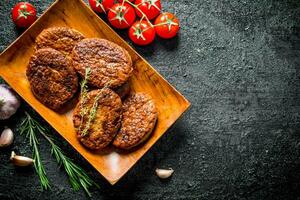 Cutlets on a plate with tomatoes and rosemary. photo
