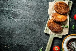 Cutlets on paper with spices in bowl. photo