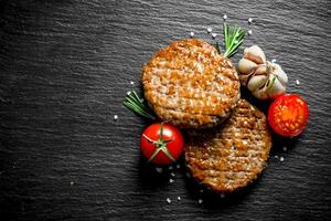 Cutlets with tomatoes,garlic and rosemary. photo