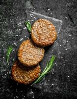 Cutlets on a black stone Board with rosemary. photo