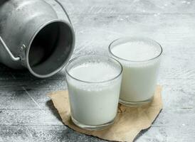 Milk in glasses with a can. photo