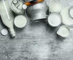 Fresh milk in glasses, bottles and jug. photo