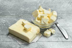 Butter in a glass bowl with a knife. photo