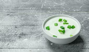 Sour cream in bowl with green onions. photo