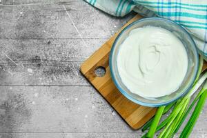 Sour cream in bowl with green onions. photo