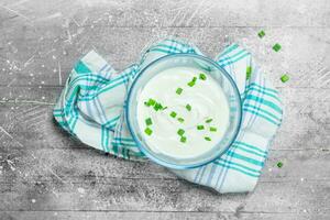 Sour cream in bowl with green onions. photo