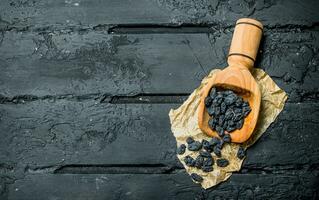 Raisins in a wooden scoop. photo