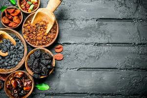 Assortment of different types of dried fruits in bowls. photo