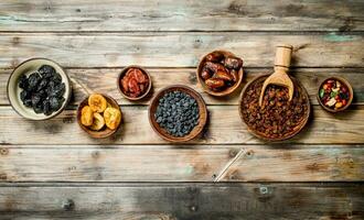 Assortment of different dried fruits in bowls. photo