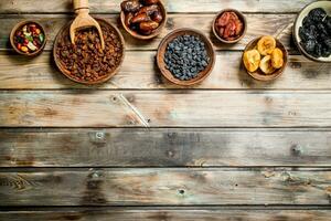 Assortment of different dried fruits in bowls. photo