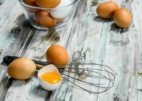 Eggs in bowl with whisk. photo