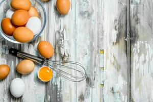 Eggs in bowl with whisk. photo