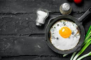 frito huevos en un pan con verde cebollas y Tomates. foto