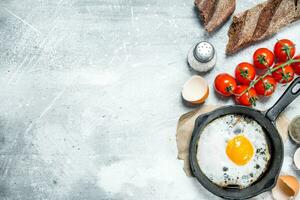 Fried egg with bread and tomatoes. photo