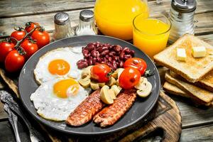 Traditional English breakfast. Fried eggs with beans, sausages and fried bread. photo