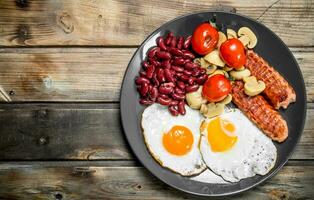 English breakfast.Fried eggs with sausages, mushrooms and beans. photo