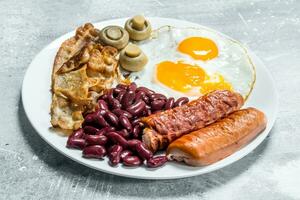 English breakfast. Fried eggs with sausages, bacon and beans. photo