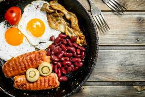 English breakfast.Fried eggs with sausages, mushrooms and beans. photo