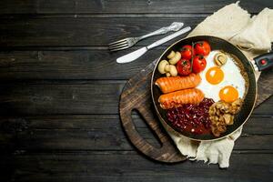 Traditional English Breakfast with fried eggs, sausages and beans. photo