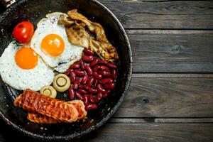 Traditional English Breakfast with fried eggs, sausages and beans. photo