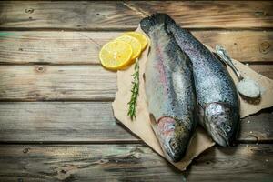 Raw sea fish with herbs and lemon wedges. photo