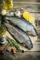 Raw sea fish salmon on old paper with lemon slices and fragrant rosemary. photo