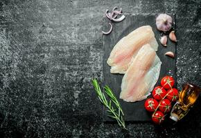 Fish fillet with rosemary,garlic and oil in the bottle. photo