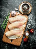 Fish fillet with spices, rosemary, garlic and oil in the bottle. photo