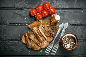 Grilled beef steak with spices and tomatoes. photo