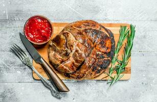 Big grilled pork steak with spices and herbs. photo