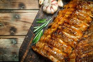 Ribs grill with branches of rosemary and garlic. photo