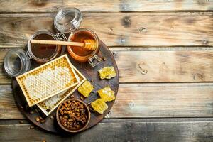 Honey in glass jars and honeycombs on the Board. photo