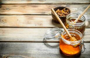 Fresh honey in a glass jar with a spoon. photo