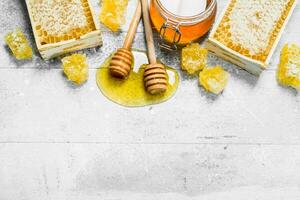 Natural honey in honeycombs with wooden spoons. photo