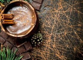 Cup of hot chocolate with cinnamon sticks. photo