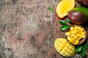 Mango pieces in a bowl with foliage. photo